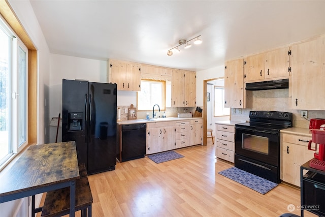 kitchen featuring light hardwood / wood-style flooring, track lighting, black appliances, sink, and light brown cabinetry