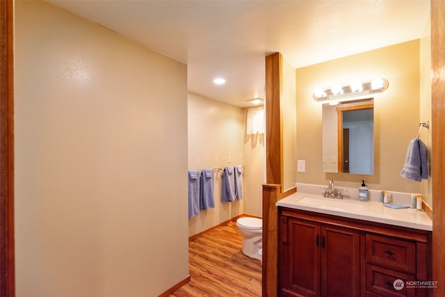 bathroom with vanity, hardwood / wood-style flooring, and toilet