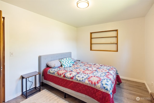 bedroom with hardwood / wood-style flooring and baseboard heating