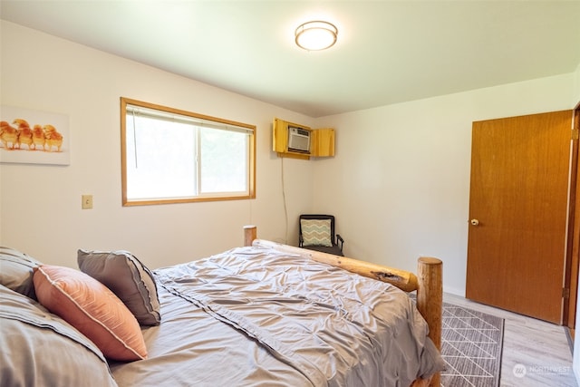 bedroom featuring a wall unit AC and wood-type flooring