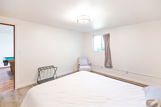 bedroom with wood-type flooring and billiards