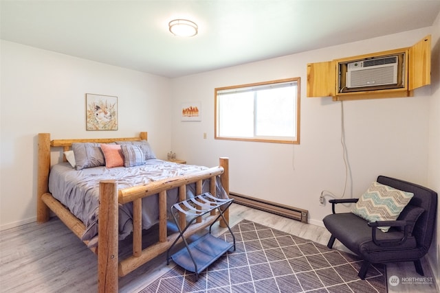 bedroom with dark hardwood / wood-style floors, a baseboard heating unit, and a wall mounted AC