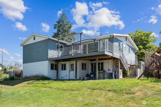 rear view of house with a deck and a yard