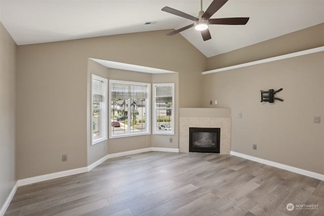 unfurnished living room with a fireplace, vaulted ceiling, hardwood / wood-style floors, and ceiling fan