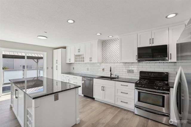 kitchen featuring a kitchen island, sink, stainless steel appliances, and light hardwood / wood-style floors