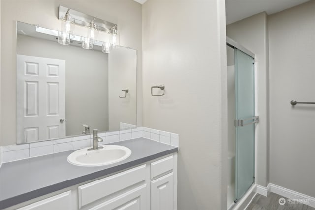 bathroom featuring a shower with shower door, vanity, and wood-type flooring