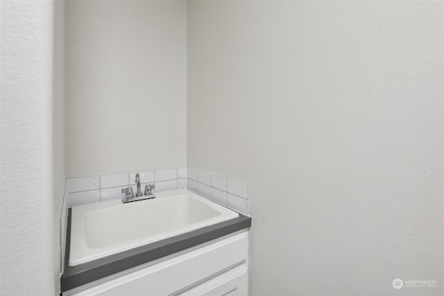 bathroom featuring vanity and tasteful backsplash