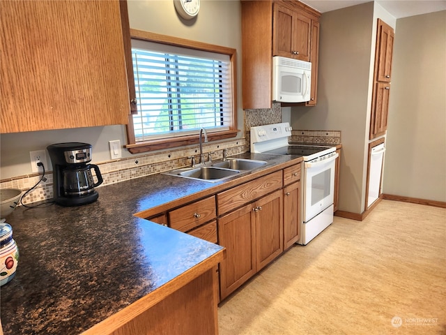 kitchen featuring white appliances, sink, and backsplash