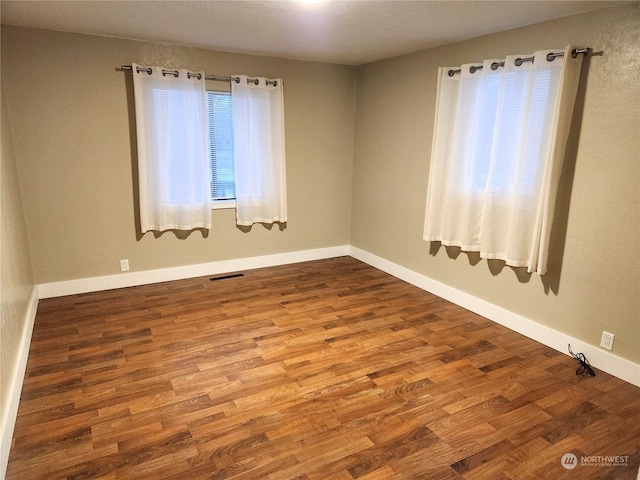 empty room with hardwood / wood-style flooring