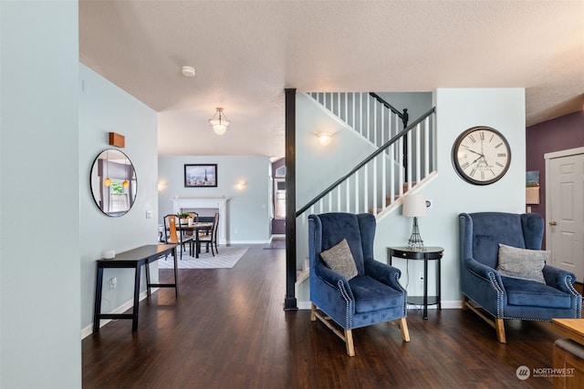 sitting room with a textured ceiling and dark wood-type flooring