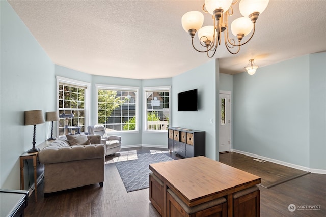 living room featuring a textured ceiling, a notable chandelier, and dark wood-type flooring