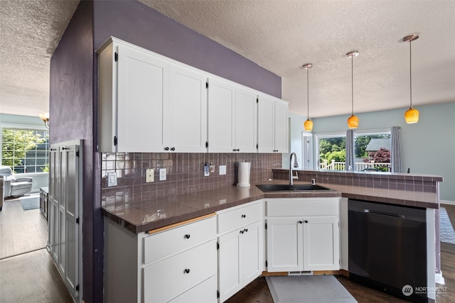 kitchen with dishwasher, white cabinets, kitchen peninsula, and sink