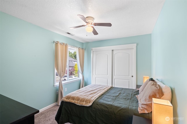 bedroom featuring carpet, ceiling fan, a textured ceiling, and a closet