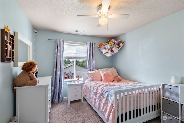 carpeted bedroom featuring a textured ceiling and ceiling fan