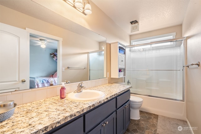 full bathroom featuring ceiling fan, enclosed tub / shower combo, a textured ceiling, toilet, and vanity