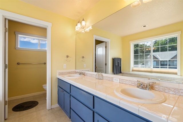 bathroom featuring vanity, a healthy amount of sunlight, and toilet