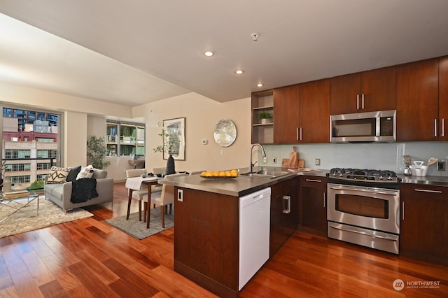 kitchen featuring kitchen peninsula, appliances with stainless steel finishes, dark hardwood / wood-style floors, and sink