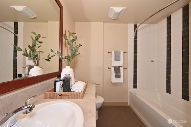 full bathroom featuring tile patterned floors, toilet, tiled shower / bath, and sink