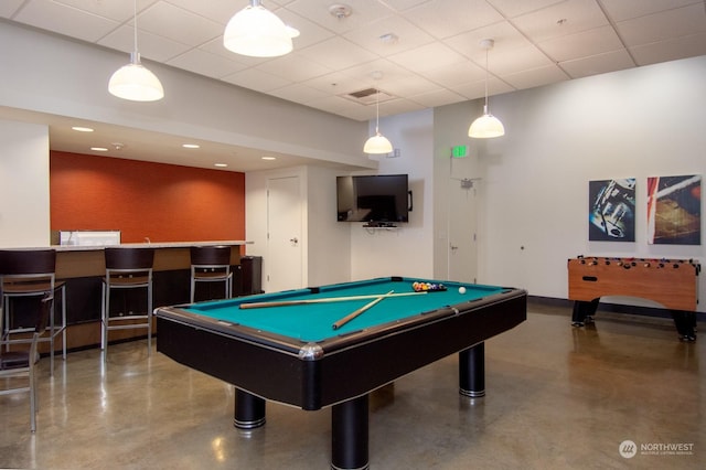 rec room with a paneled ceiling, concrete flooring, and billiards