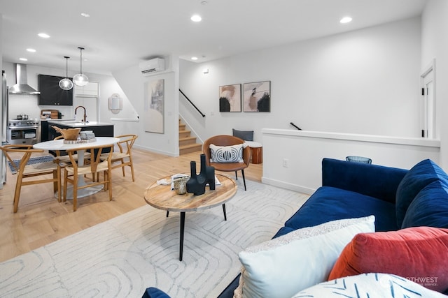 living room with light wood-type flooring, a wall mounted AC, and sink