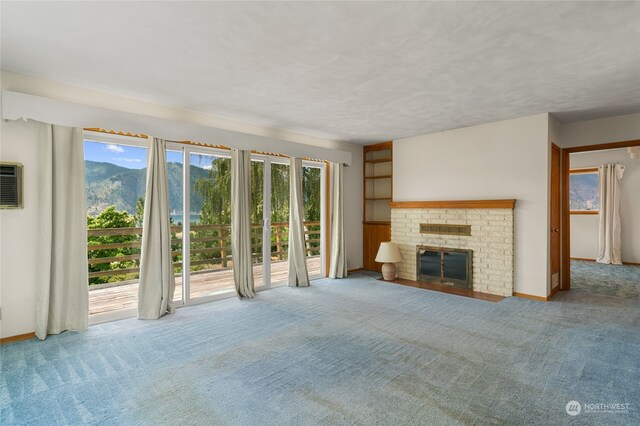 unfurnished living room with a healthy amount of sunlight, a brick fireplace, and carpet floors