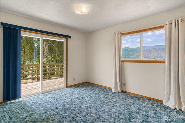 carpeted spare room with a mountain view and a wealth of natural light