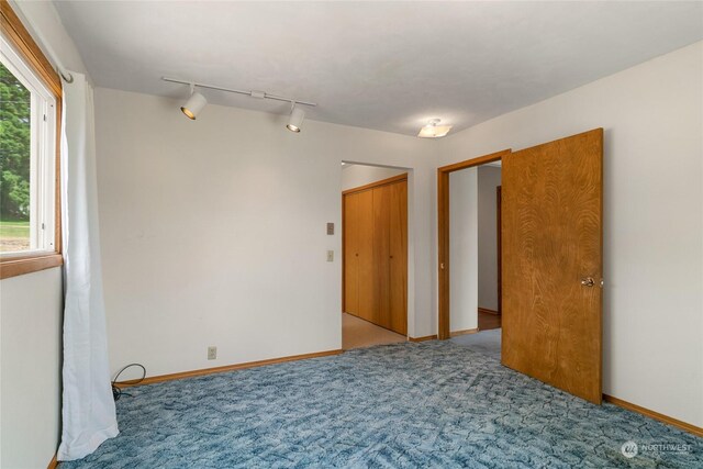 carpeted spare room featuring track lighting