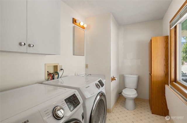 laundry area featuring light tile flooring, washer hookup, and washing machine and clothes dryer