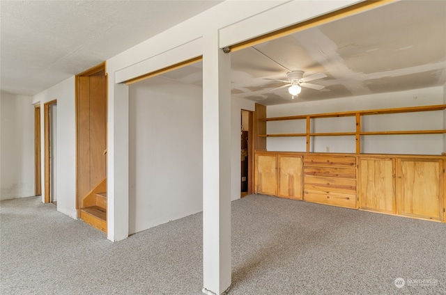 basement featuring light carpet and ceiling fan