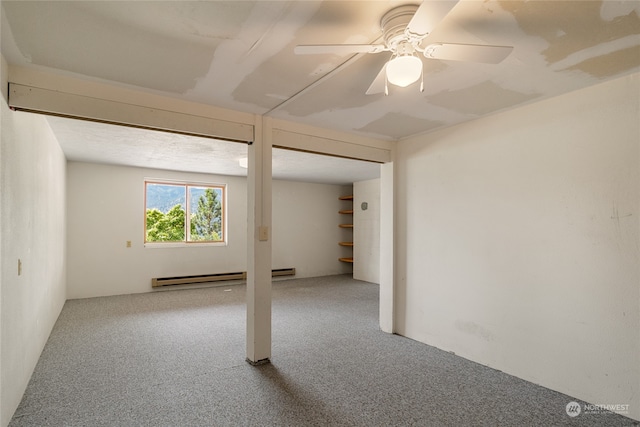 basement with baseboard heating, carpet floors, and ceiling fan