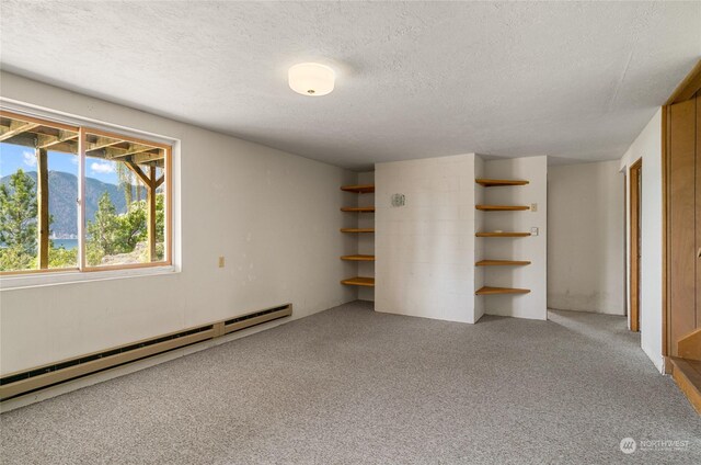 unfurnished bedroom featuring a baseboard heating unit, a textured ceiling, and carpet flooring