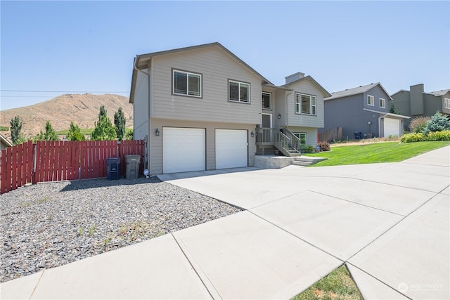 raised ranch with a mountain view, a garage, and a front yard