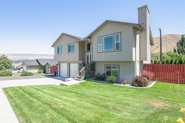 view of front facade featuring a mountain view, a garage, and a front lawn