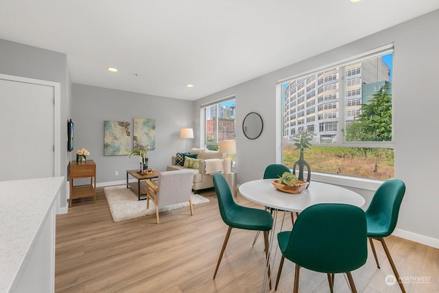 dining area with light hardwood / wood-style floors and a wealth of natural light