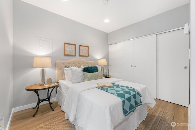 bedroom with light hardwood / wood-style floors and a closet