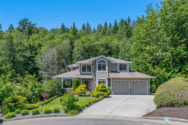3377 Topaz Ct, Bellingham, WA 98226 - view of front of home featuring stone siding, concrete driveway, a view of trees, and an attached garage