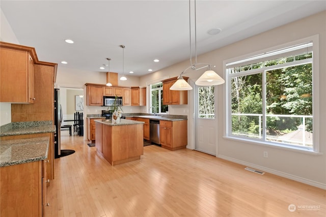 kitchen with sink, a center island, hanging light fixtures, and appliances with stainless steel finishes