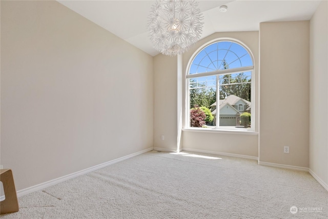 carpeted spare room featuring lofted ceiling and a notable chandelier