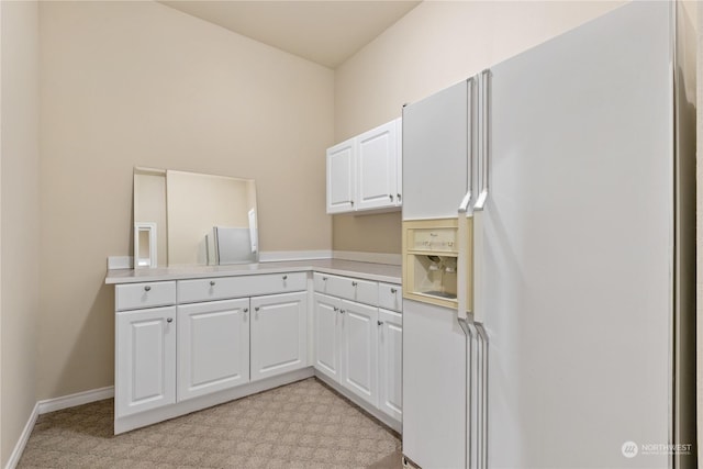 kitchen featuring kitchen peninsula, white cabinetry, white refrigerator with ice dispenser, and light carpet