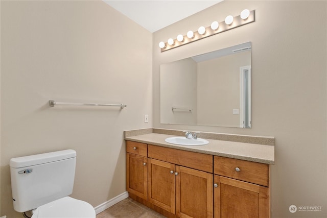 bathroom with tile patterned flooring, vanity, and toilet