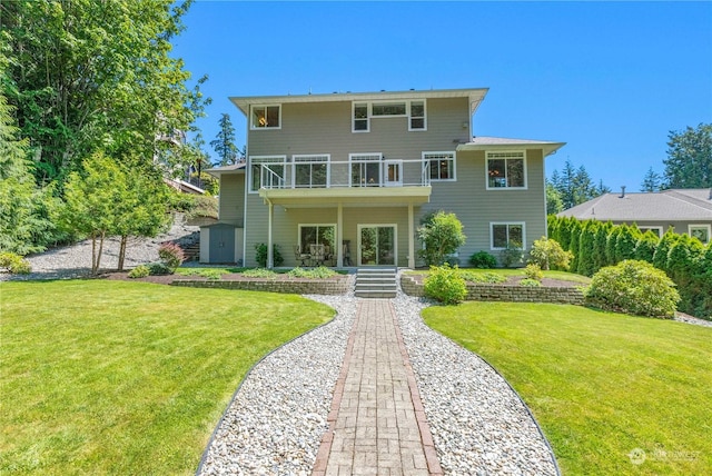 back of property with a yard and a balcony