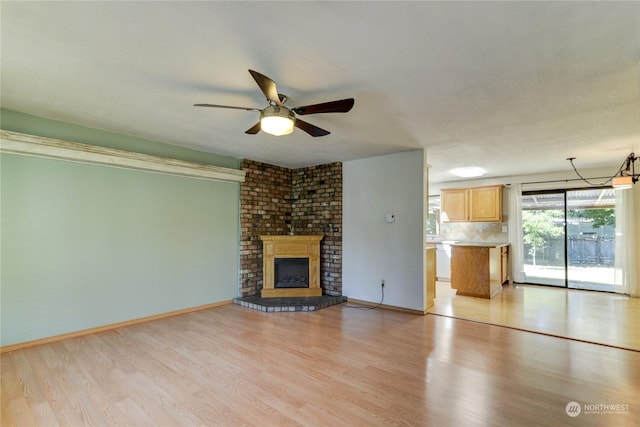 unfurnished living room with a fireplace, light hardwood / wood-style flooring, and ceiling fan