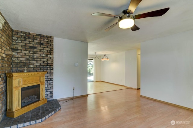 unfurnished living room with ceiling fan, a fireplace, and light hardwood / wood-style flooring