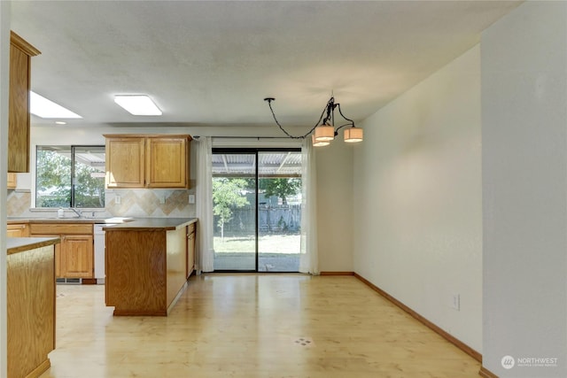 kitchen with dishwasher, an inviting chandelier, tasteful backsplash, light hardwood / wood-style floors, and decorative light fixtures