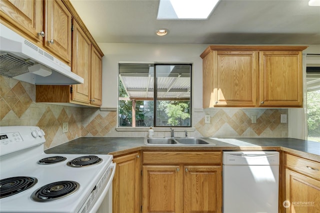 kitchen with decorative backsplash, white appliances, sink, and a skylight