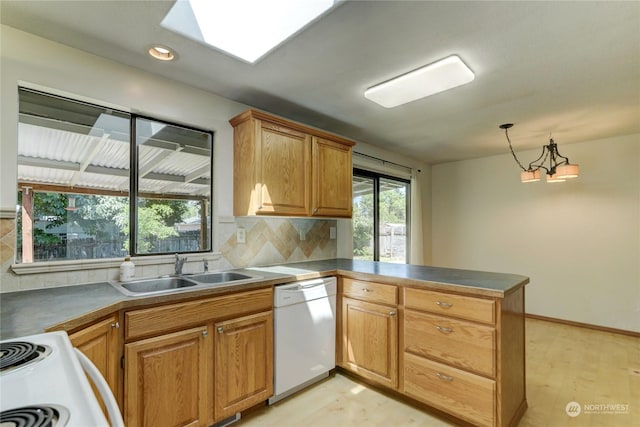 kitchen with sink, a notable chandelier, backsplash, kitchen peninsula, and white dishwasher