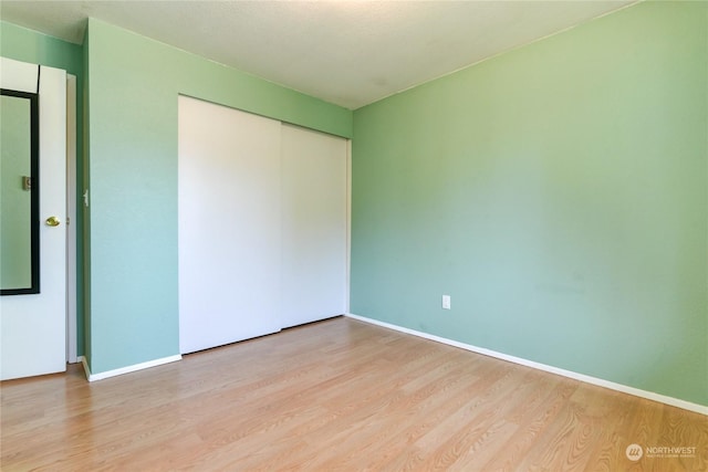 unfurnished bedroom featuring light hardwood / wood-style floors and a closet