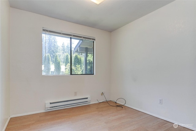 spare room with a baseboard radiator and light hardwood / wood-style floors