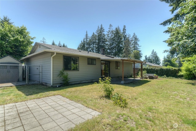 back of house featuring a lawn and a patio area