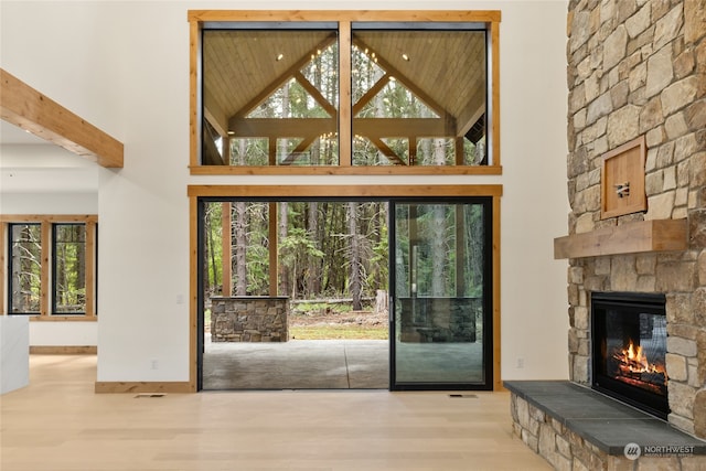 entryway with a fireplace, a towering ceiling, and a healthy amount of sunlight